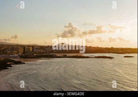 Tramonto sulla baia costiera e sulle onde oceaniche Foto Stock