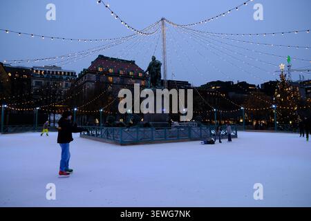 Stoccolma, Svezia - 27 novembre 2025: Pattinatori sulla pista di pattinaggio a Kungsträdgården a Stoccolma, Svezia al crepuscolo Foto Stock