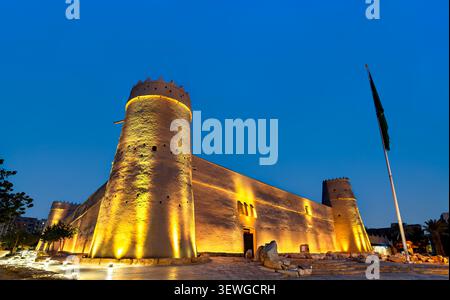 La storica Fortezza di al Masmak si erge illuminata contro il cielo blu dell'ora nel centro storico di Riad, Arabia Saudita. Foto Stock