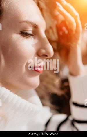 Donna profilo bellezza Ritratto di una giovane donna con gli occhi chiusi e i capelli ricci sotto la luce solare dorata durante il giorno Foto Stock