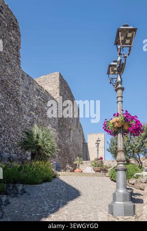 Paesaggio urbano con il bastione del castello di Doria presso il villaggio storico sulla riva del Mediterraneo, fotografato in primavera a Castelsardo, Sassari, Italia Foto Stock