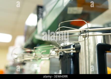Una vista ravvicinata degli accessori del mixer manuale su un ripiano della cucina, che mostra il design elegante e le funzionalità per le attività di miscelazione e cottura Foto Stock