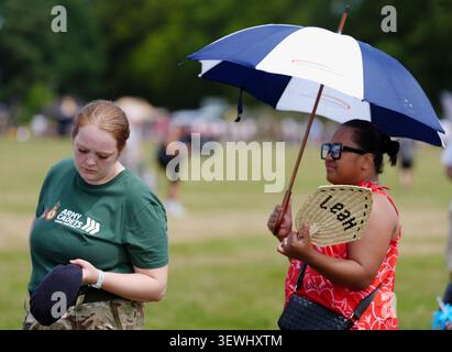 Le persone fanno la fila per un evento dell'Armed Forces Day ad Aldershot, Hampshire. Le temperature scenderanno con gli avvisi di temporale emessi a seguito di un'onda di calore che ha visto la temperatura record di giugno interrotta per tre giorni di seguito. Venerdì è stato confermato dal Met Office come il giorno di giugno più caldo del Regno Unito mai registrato, con una temperatura provvisoria di 37,3C registrata a Santon Downham, Suffolk, superando il massimo di 36,7C registrato a Merryfield, Somerset, giovedì. Data foto: Sabato 27 giugno 2026. Foto Stock
