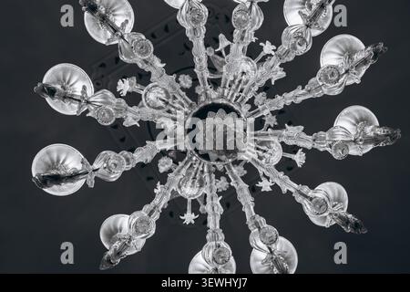 Vista ad alto angolo degli amici riuniti intorno a un tavolo luminoso con cibo e vino al buio, condividendo un pasto la sera in una calda serata estiva. Ciao Foto Stock