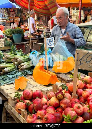 Mercato di Ballarò a Palermo, in Sicilia, con bancarelle di frutta e verdura colorate, che catturano l'atmosfera vibrante della tradizionale vita di strada siciliana. Foto Stock