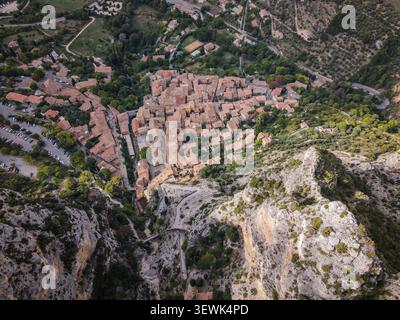 Una prospettiva aerea cattura il pittoresco villaggio di Moustiers-Sainte-Marie in Provenza, in Francia, con i suoi caratteristici tetti con tegole di terracotta Foto Stock