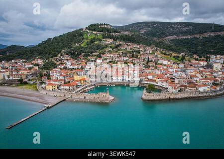 Una prospettiva aerea mostra la città costiera di Gytheio, in Grecia, con il suo porto, la spiaggia sabbiosa e gli edifici con tetti di tegole rosse. Nel bac Foto Stock