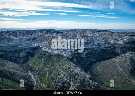Un'ampia vista aerea cattura le antiche abitazioni rupestri di Matera, in Italia, annidate nel suggestivo canyon di Gravina. La città storica, caratteristica Foto Stock