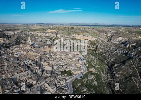 Un'ampia vista aerea cattura le antiche abitazioni rupestri dei Sassi di Matera, con i suoi edifici in pietra pallida e la Cattedrale di Matera, annidata in Foto Stock