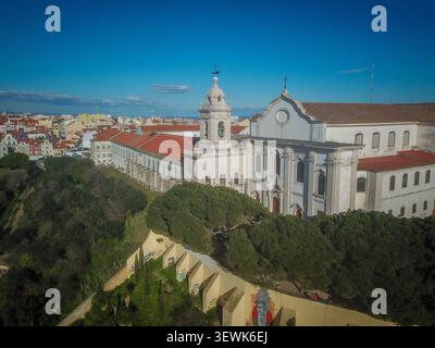 Un grandangolo aereo cattura la facciata bianca del monastero e della chiesa di São Vicente de Fora a Lisbona, in Portogallo, con i tetti di tegole rosse di t Foto Stock