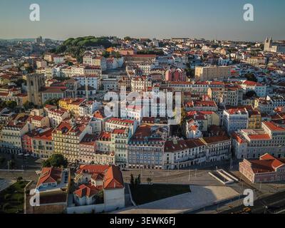 Un grandangolo aereo cattura il fitto paesaggio urbano di Lisbona, Portogallo, con numerosi edifici a più piani con tetti di tegole rosse e li Foto Stock
