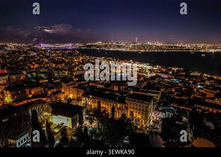 Un grandangolo aereo cattura la città illuminata di Istanbul di notte, con lo stretto del Bosforo e il ponte Fatih Sultan Mehmet visibili Foto Stock