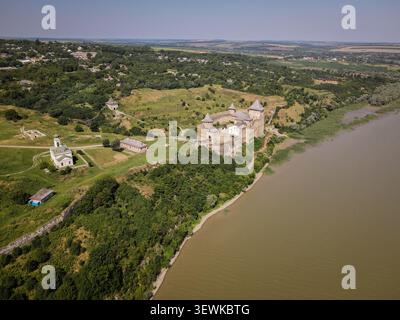Un grandangolo aereo cattura la fortezza di Khotyn e il fiume Dniester dall'alto, con verdi colline circostanti, alberi e villaggi lontani. Questo Foto Stock