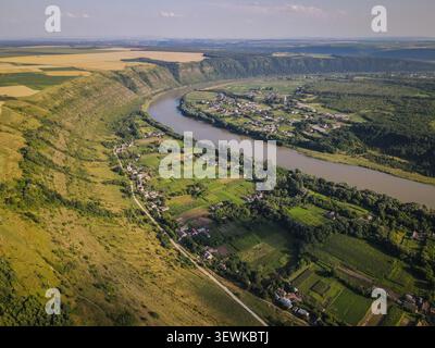 Uno scatto aereo cattura il fiume Dniester che si snoda attraverso una lussureggiante valle verde, fiancheggiata da ripide colline boscose e campi agricoli, con sma Foto Stock