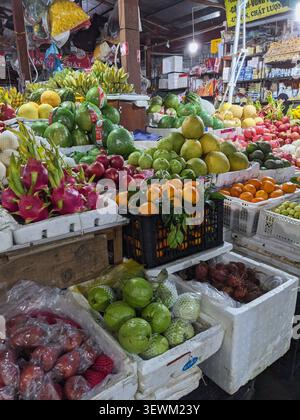 Un vibrante assortimento di frutta tropicale fresca e' splendidamente organizzato in un vivace mercato vietnamita Foto Stock