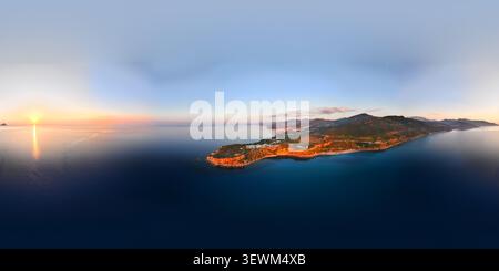 Vista aerea del paesaggio costiero di Pollina al tramonto, caratterizzato da aspre scogliere, vegetazione mediterranea e il mare calmo di Pollina, Sicilia, IT Foto Stock