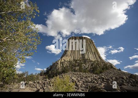 Vista dal basso angolo del Devils Tower National Monument sotto le nuvole spettacolari e il cielo blu nel nord-est del Wyoming, Stati Uniti. Foto Stock