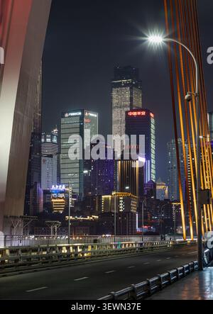 Chongqing, Cina - 10 giugno 2026 - contro il cielo notturno di Chongqing, un magnifico arazzo di grattacieli torreggianti illuminati in rubino e zaffa Foto Stock