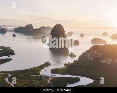 Vista aerea del punto panoramico di Samet Nangshe con formazioni carsiche calcaree che si innalzano dalle calme acque della baia e lussureggianti mangrovie all'alba a Tambon Khlong Khian, Chang W. Foto Stock