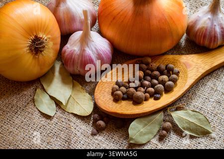 Allspezia, cipolla, aglio e alloro. Spezie e verdure primo piano. Foto Stock