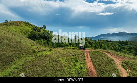 Questa vista mozzafiato con droni cattura la bellezza di una natura selvaggia incontaminata, dove creste erbose e foreste lussureggianti creano un contrasto sorprendente sotto il caldo Foto Stock