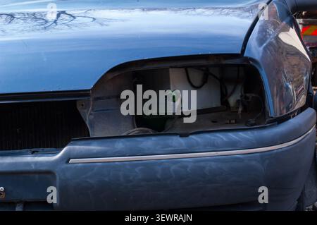 primo piano di un faro mancante di un'auto che mostra il cablaggio esposto Foto Stock