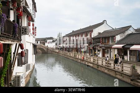 Tradizionali edifici sul lungomare e ponte in pietra che costeggia un canale panoramico Foto Stock