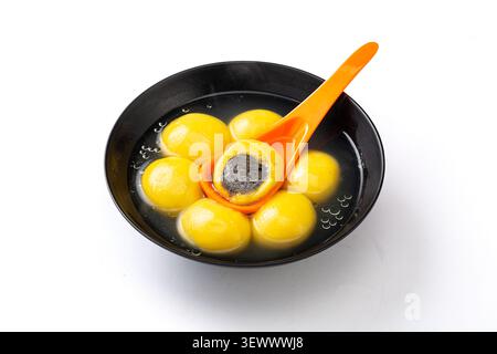 Tangyuan di miglio giallo cotto con ripieno di sesamo nero, sezione trasversale della tradizionale palla di riso dolce cinese Foto Stock