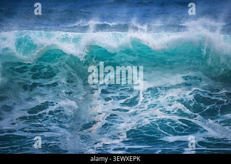 Primo piano di onde marine che si infrangono con schiuma bianca e spruzzo d'acqua Foto Stock