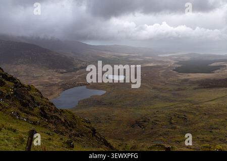 Vista panoramica dal Conor Pass sotto un suggestivo cielo nuvoloso, contea di Kerry, Irlanda Foto Stock
