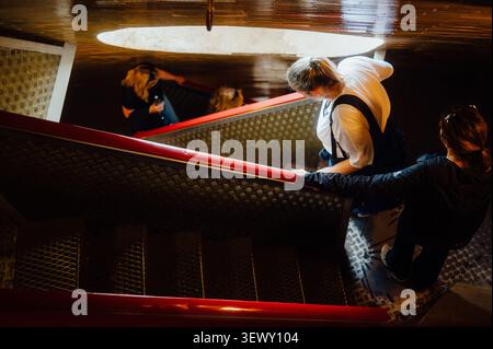 I visitatori scendono la scalinata all'interno della cupola della basilica di San Pietro Foto Stock