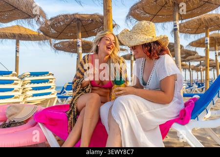 Giovani donne felici che si godono le vacanze estive in spiaggia Foto Stock