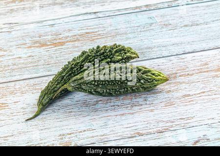 Due buongustai amari verdi freschi che giacciono su un tavolo di legno blu chiaro. Fotografia gastronomica minimalista con luce naturale. Concetto per un'alimentazione sana, Foto Stock