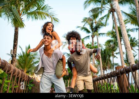 Viaggiatori felici che esplorano una destinazione tropicale con palme durante una vacanza estiva Foto Stock