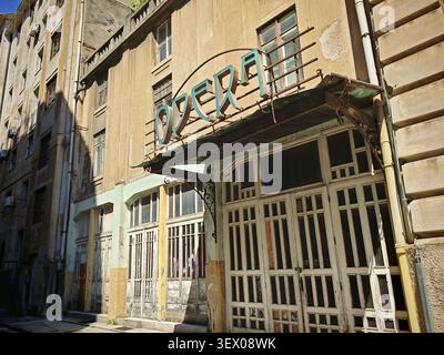 Un vecchio teatro dell'opera, con la scritta "opera", Teatro Fenice, con facciata storica fatiscente in un ambiente urbano, Rijeka, Croazia Foto Stock