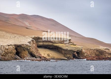 Aspre scogliere costiere e grotte marine delle Isole Ballestas che si innalzano sopra le acque del Pacifico vicino a Paracas Foto Stock