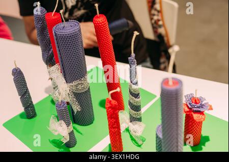 Candele fatte a mano in cera d'api esposte al mercato dell'artigianato con candele colorate in cera arrotolate Foto Stock
