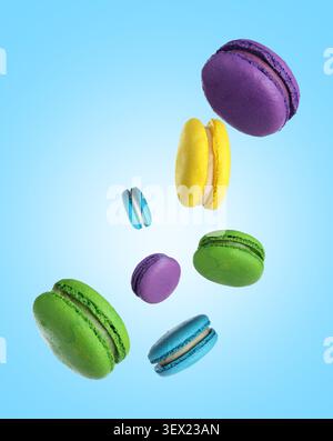 Saporiti macaron colorati che cadono su sfondo azzurro Foto Stock