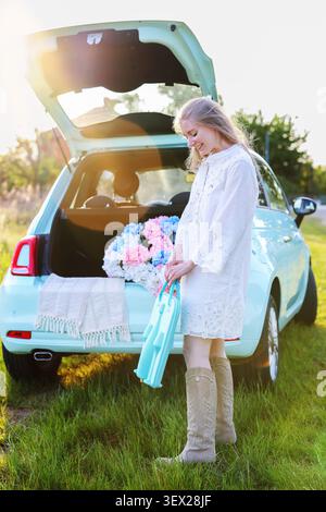 scena di campagna con una giovane donna, ortensie in fiore e un'auto pastello, che cattura la libertà, il tempo libero e le vibrazioni estive Foto Stock