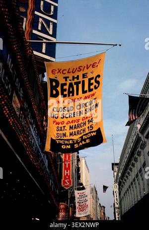 Immagine storica di uno striscione all'esterno del Paramount Theater di Boston che pubblicizza un esclusivo spettacolo a circuito chiuso dei Beatles, con tendoni teatrali e un paesaggio urbano. 1964. Foto Stock