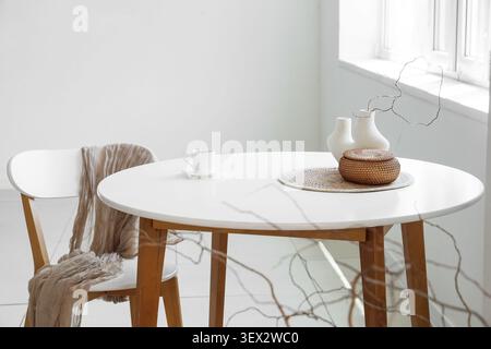 Tavolo da pranzo minimalista con sedia e articoli decorativi Foto Stock