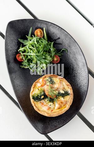 quiche di salmone e broccoli con insalata pasto sano sul tavolo da caffè bianco a ibiza Foto Stock