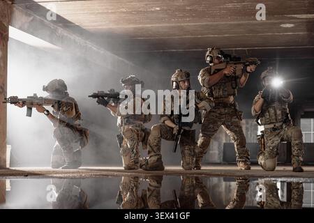 Squadra tattica militare che si muove attraverso il fumo durante la missione di combattimento, l'azione delle forze speciali, le operazioni di difesa e sicurezza. Foto Stock