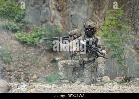 Soldati delle forze speciali STATUNITENSI impegnati in operazioni di combattimento, manovre di squadra militare moderna, ambiente di guerra tattica, distacco professionale delle forze armate Foto Stock