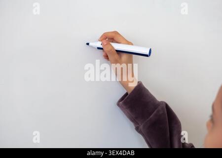Questa vista ravvicinata di una scrittura a mano con un pennarello blu su una lavagna bianca pulita cattura un momento di apprendimento, ideazione aziendale strategica o interattiva Foto Stock