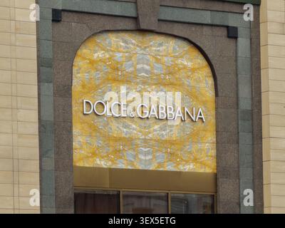 Kiev, Ucraina - 21 marzo 2026: Una targa Dolce e Gabbana esposta su una lastra di marmo giallo lucido incorniciata da archi di granito trasmette prestigio, e. Foto Stock