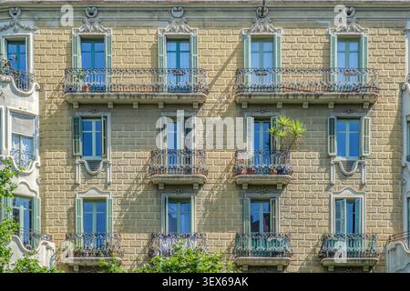 Barcellona - Spagna - 05-31-2026: Facciata con finestre verdi e balconi, ringhiere in ferro battuto, esterno dell'appartamento storico Foto Stock