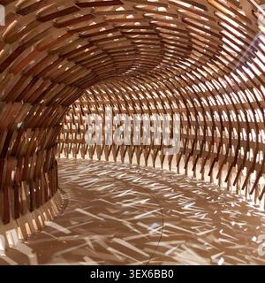 Un tunnel architettonico avvolgente e curvo costruito con spranghe di legno interlacciate, che diffonde complessi schemi di luce geometrici lungo il percorso interno Foto Stock
