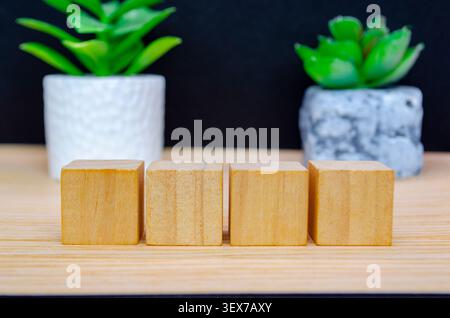 Podio a cubetti in legno con piante decorative in vaso su uno sfondo pulito per vetrine e pubblicità di prodotti moderni Foto Stock