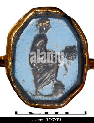 Un anello intaglio di nicolo, 'Thalie', con Thalia, la musa greca della commedia, in piedi e tenendo in mano una maschera, con un intaglio ottagonale e un'iscrizione greca sul monte d'oro, creata nel III secolo. Foto Stock